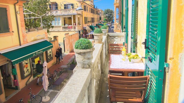 A narrow street with buildings on either side, a bench, and a table with a basket of lemons. - Via Dante Vacanze - large apartment for 4 people, 200 meters from the beach, in Levanto (Levanto)
