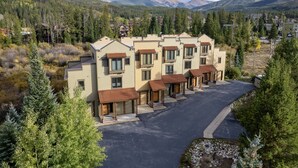 A multi-story residential building with a parking area in front. - 102 Willows Way 3 Bedroom Townhouse by RedAwning (Winter Park)