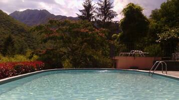 Een seizoensgebonden buitenzwembad, parasols voor strand/zwembad