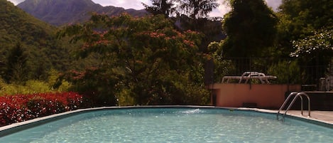 En säsongsöppen utomhuspool, parasoller och solstolar