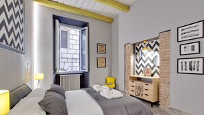 A bedroom with a bed, a window, a dresser, and wall decorations. - Rome as you feel - Design at Colosseum (Rome)