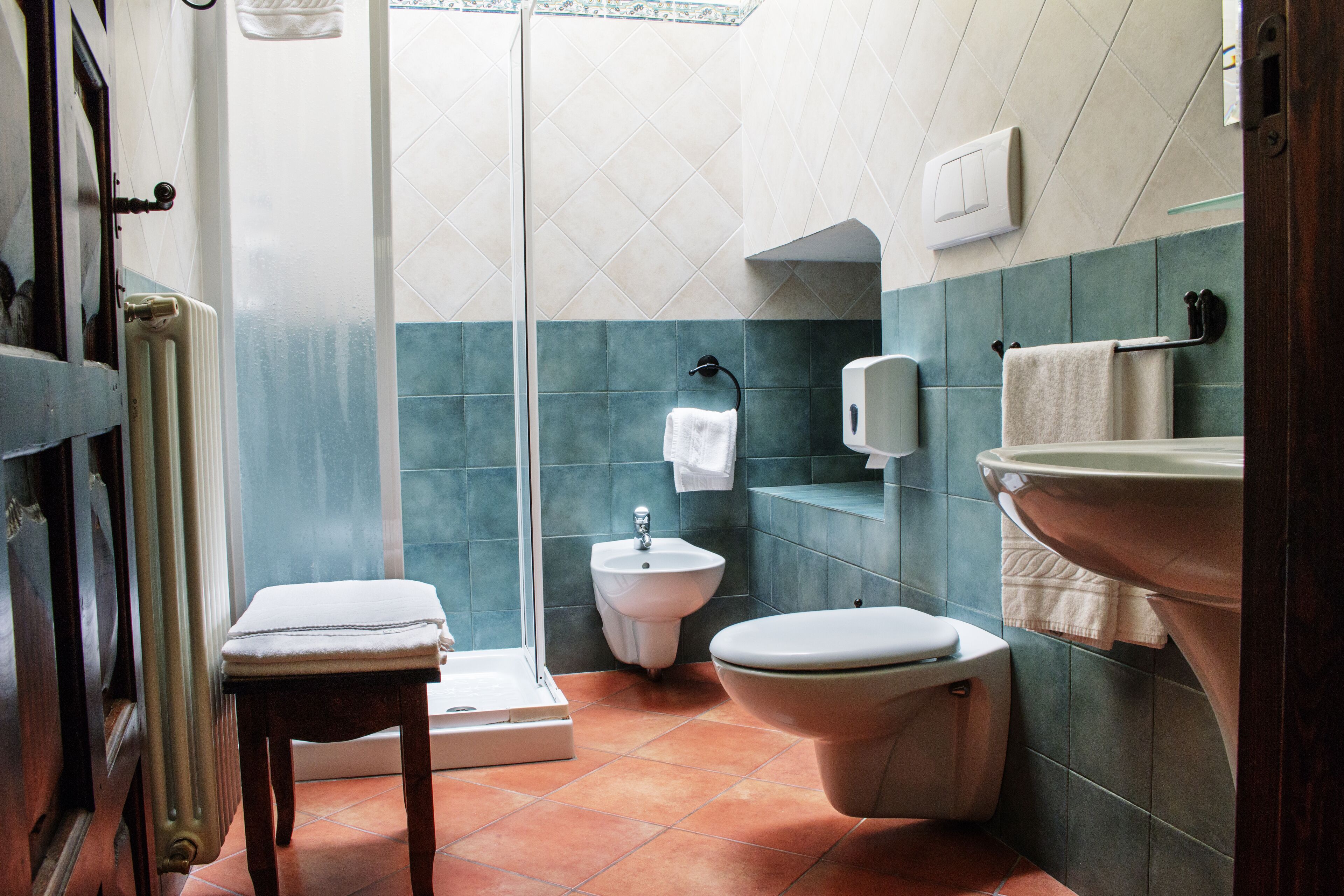 Un baño con ducha, inodoro, bidé y lavamanos.