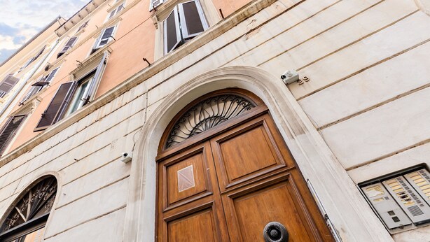 Una puerta de madera grande con un arco decorativo y dos pomos de metal redondos.