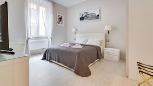 Una habitación de hotel moderna con una cama grande, mesitas de noche, un escritorio y una silla.