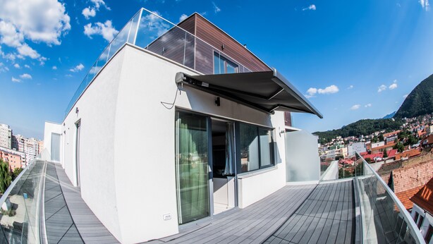 Un edificio moderno con fachada blanca, ventanas grandes y un balcón.