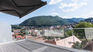Un balcón con vistas a un pueblo y una colina.