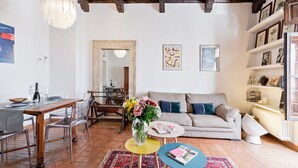 Un salon comprenant un coin repas, un canapé, une table basse et une bibliothèque.