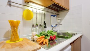 A kitchen with a sink, a cutting board, and various kitchen utensils. - Rome as you feel - Piazza dei Satiri Studio (Rome)