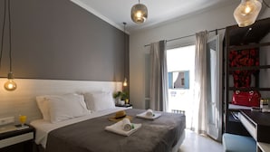A neatly made bed with white linens, a bedside table with a lamp, and a red handbag on a shelf. - ANNUNZIATA URBAN SUITES by LOC HOSPITALITY (Corfu)