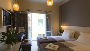 A hotel room with two beds, a desk with a computer, a TV, and a potted plant. - ANNUNZIATA URBAN SUITES by LOC HOSPITALITY (Corfu)