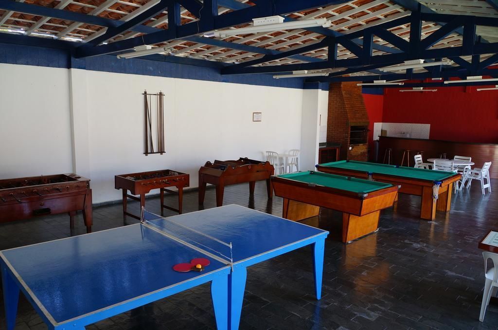 Una sala de billar con varias mesas y sillas, mobiliario de madera y un techo alto con vigas a la vista.