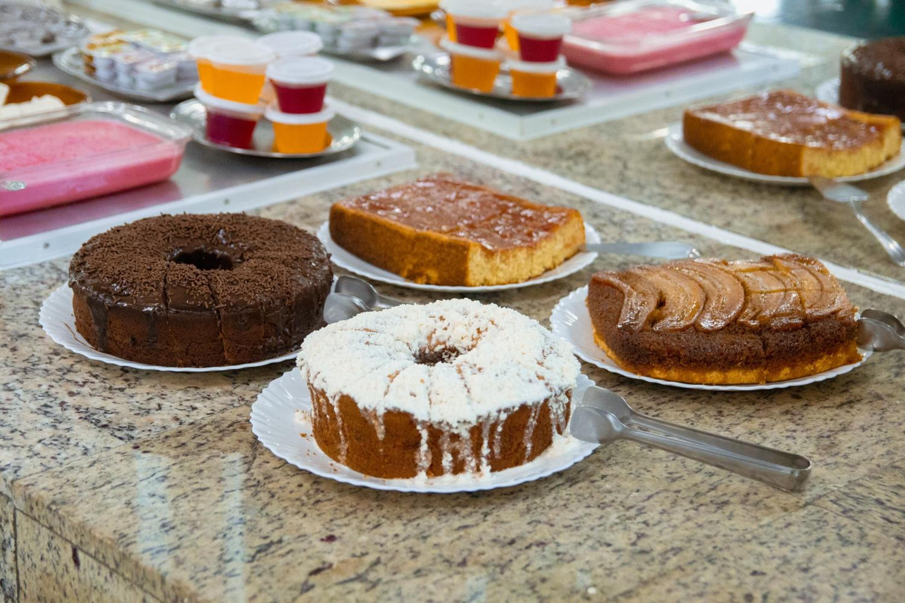 A variety of cakes on a marble countertop.