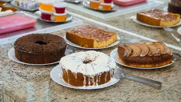 A variety of cakes on a marble countertop.