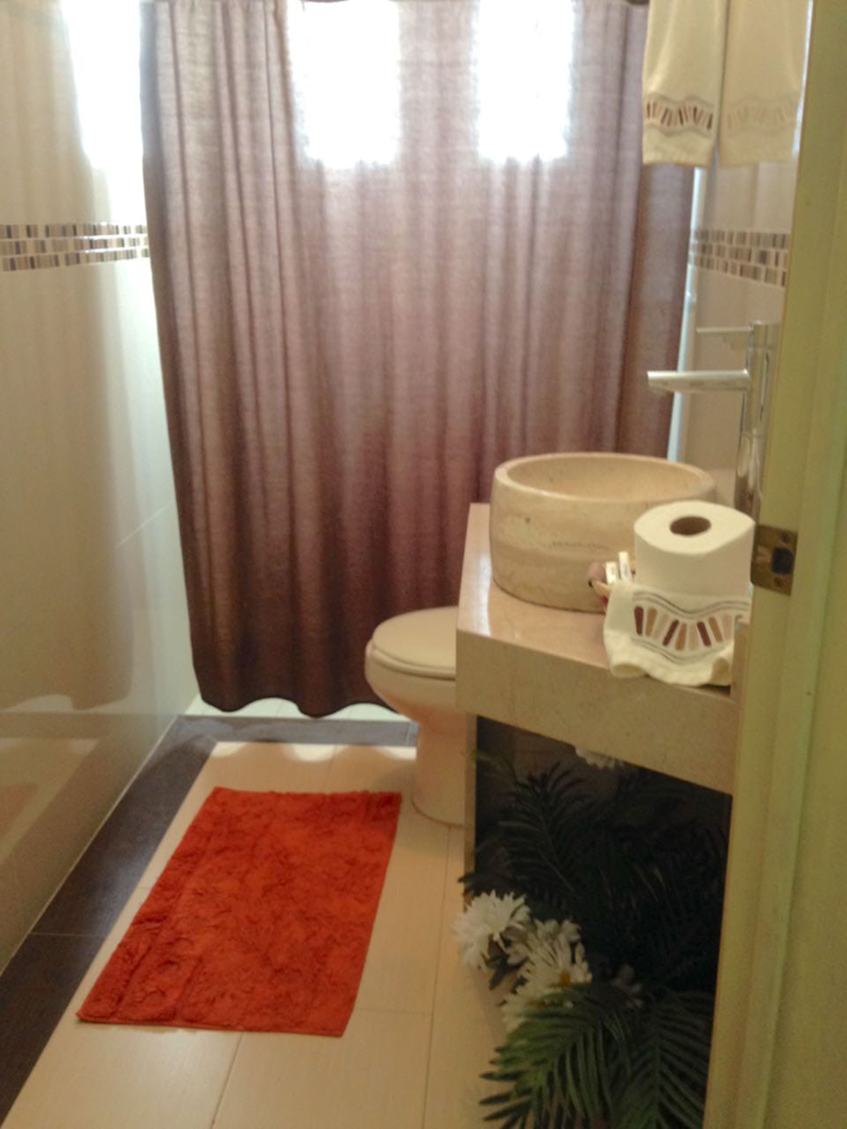 Une salle de bain comprenant des toilettes, un lavabo et un espace douche.