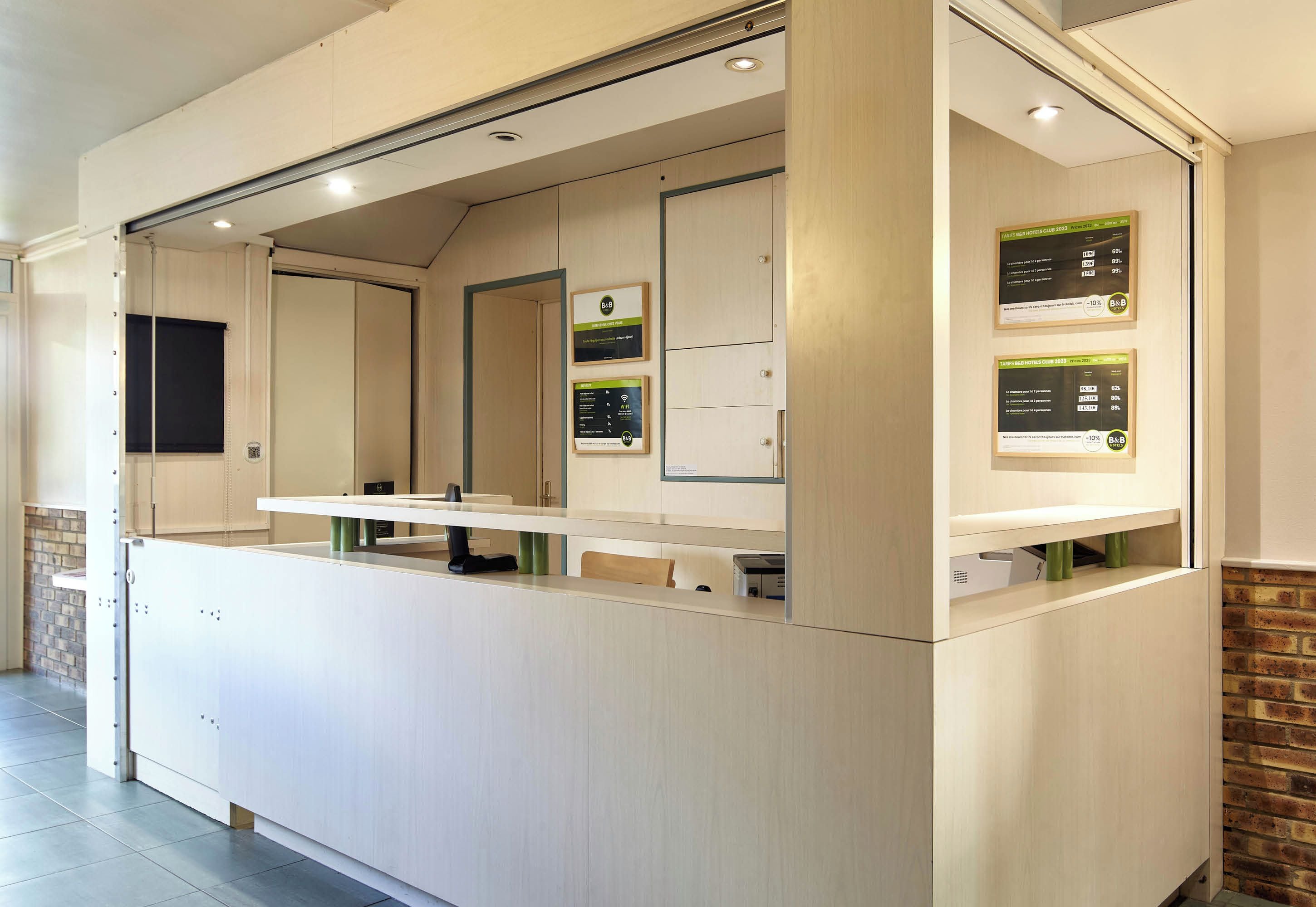 A reception area with a counter, a mirror, and informational posters.