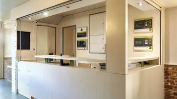 A reception area with a counter, a mirror, and informational posters.