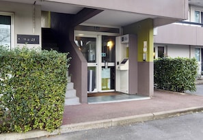 A building entrance with a glass door, a staircase, and a sign indicating room number 9.