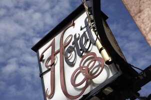 Una señal con la palabra 'Hotel' en una fuente decorativa.