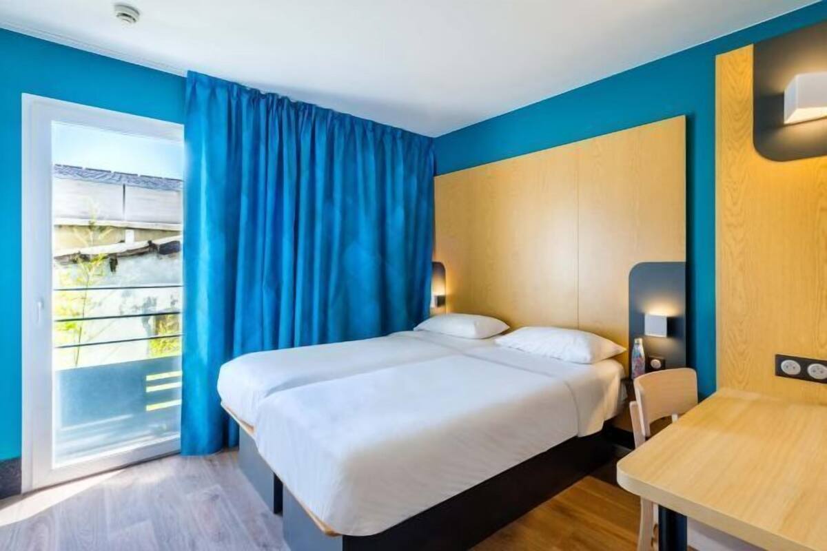 Une chambre d’hôtel avec un lit, une table et une vue sur l’extérieur.