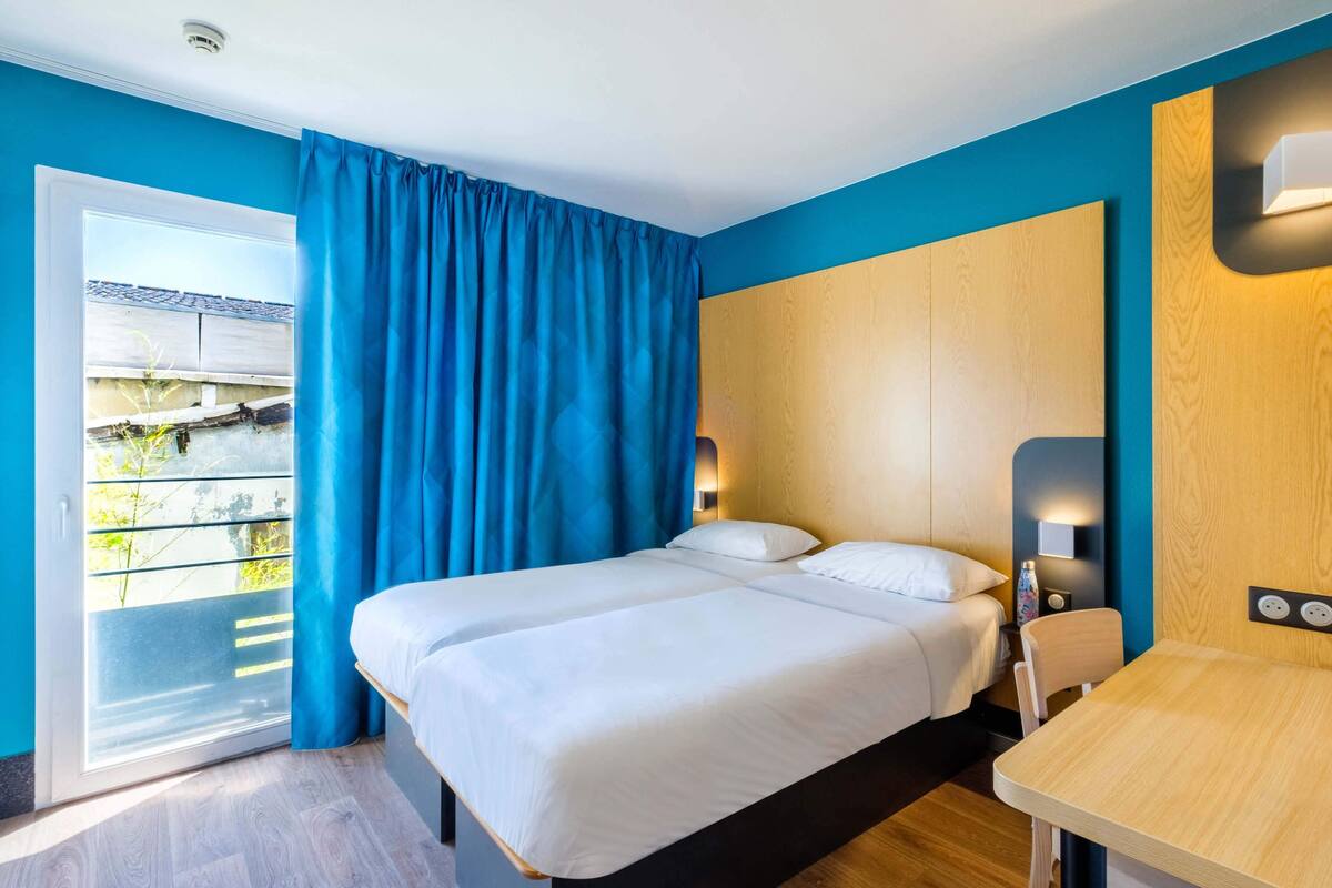 Une chambre d’hôtel avec un lit, une table et une vue sur l’extérieur.
