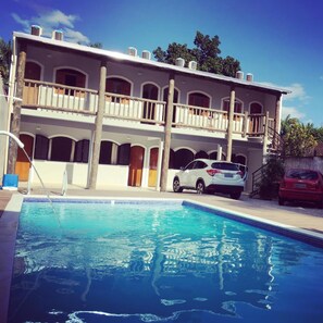 Una piscina al aire libre, tumbonas