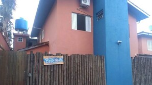 Um edifício com cerca de madeira e um letreiro que diz 'Vossa do Passeio'.