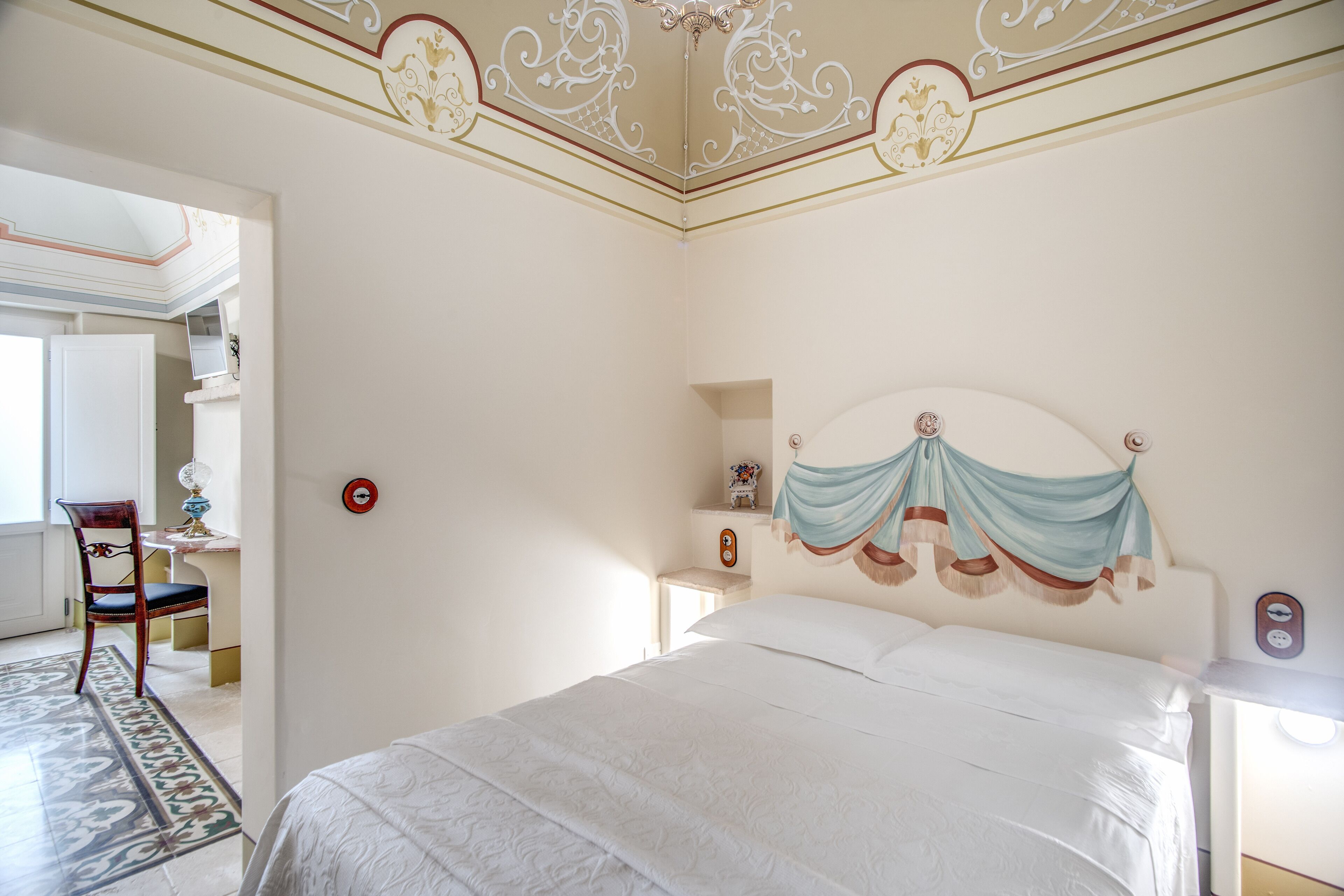 Une chambre à coucher comprenant un lit, une chaise, une table de chevet et une tête de lit décorative.