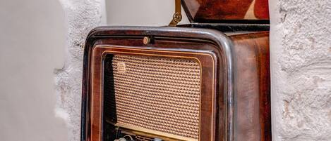 A vintage radio set mounted on a white textured wall.