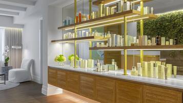 Bathroom features a vanity with mirror and shelf for toiletries, a chair, and a small table.