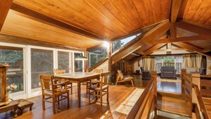 A wooden interior with a dining area, a staircase, and a seating area.