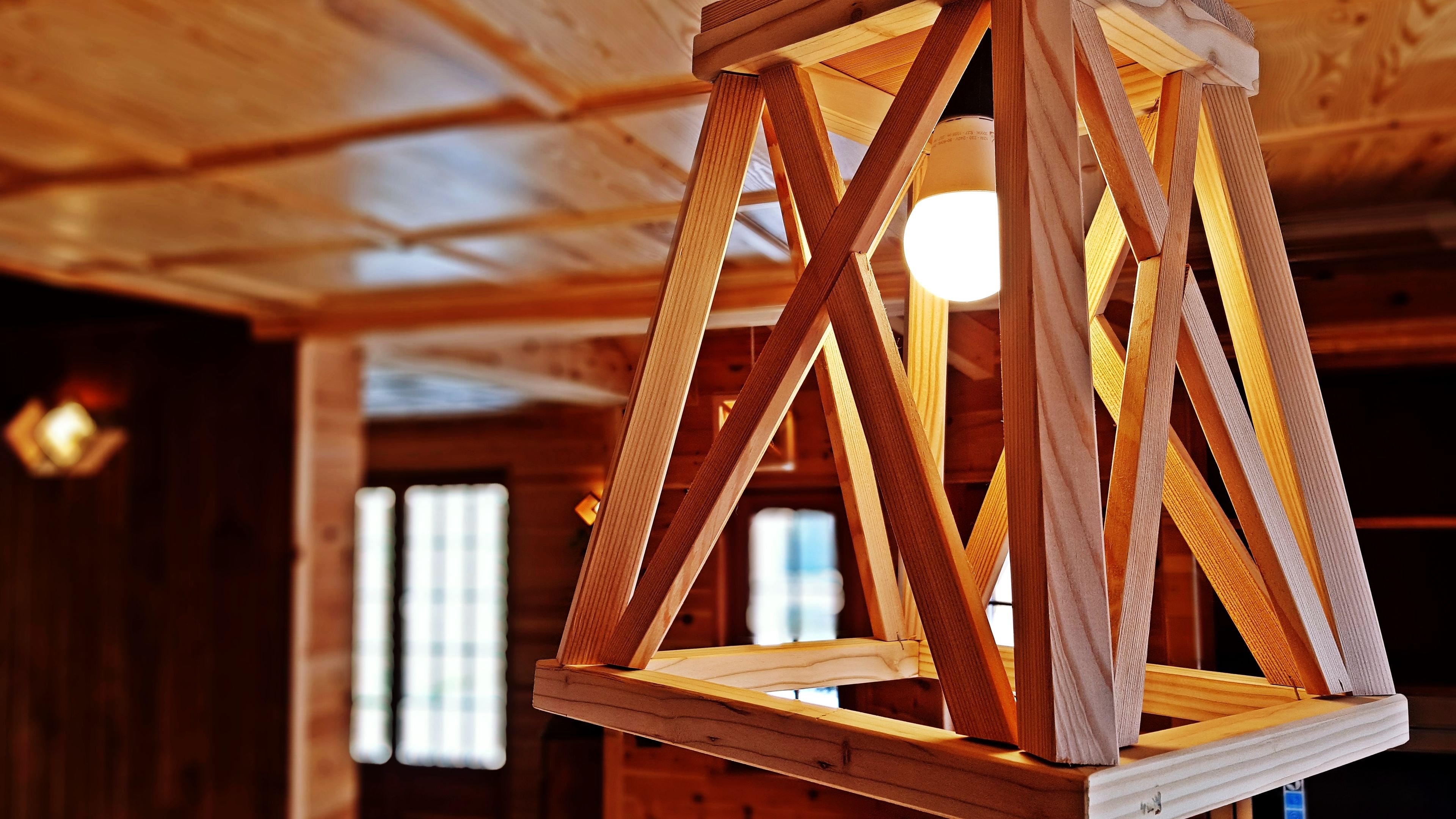 Eine Holzbalkendecke mit freiliegenden Holzbalken und einer hängenden Leuchte.