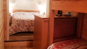 Una stanza accogliente con un letto a castello, una scrivania e un letto con copripiumino floreale.