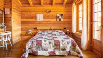 Een blokhutkamer met een bed, een bureau en een stoel.