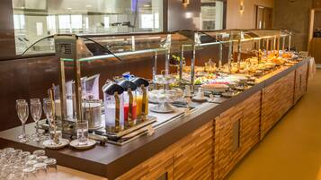 A buffet with various food items and a glass display case with drinks.