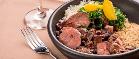A bowl of food with rice, meat, and vegetables.