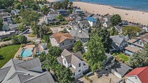 A residential area with houses, a swimming pool, and a beach.