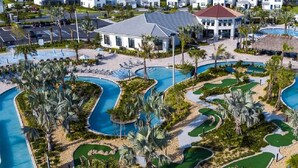 A resort with multiple swimming pools, palm trees, and a building with a red roof. - 6BR Luxury Villa: Pool, Spa, Game Room & Disney Magic 2957 FS (Kissimmee)