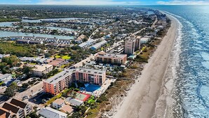 Un hôtel situé sur la côte, composé de plusieurs bâtiments, avec une plage et un port de plaisance.