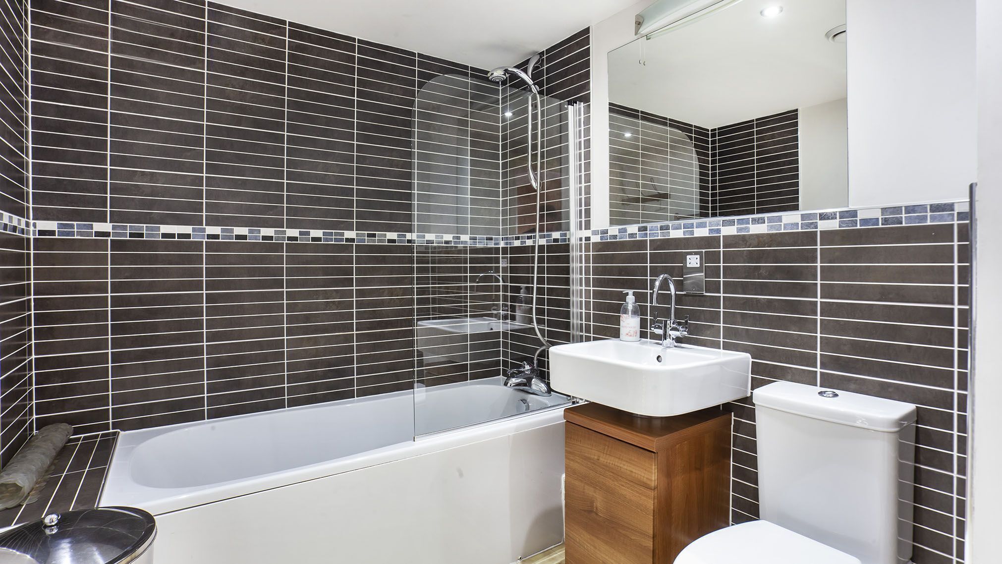 Ein modernes Badezimmer mit einer Badewanne, einem weißen Waschbecken und einer Toilette.