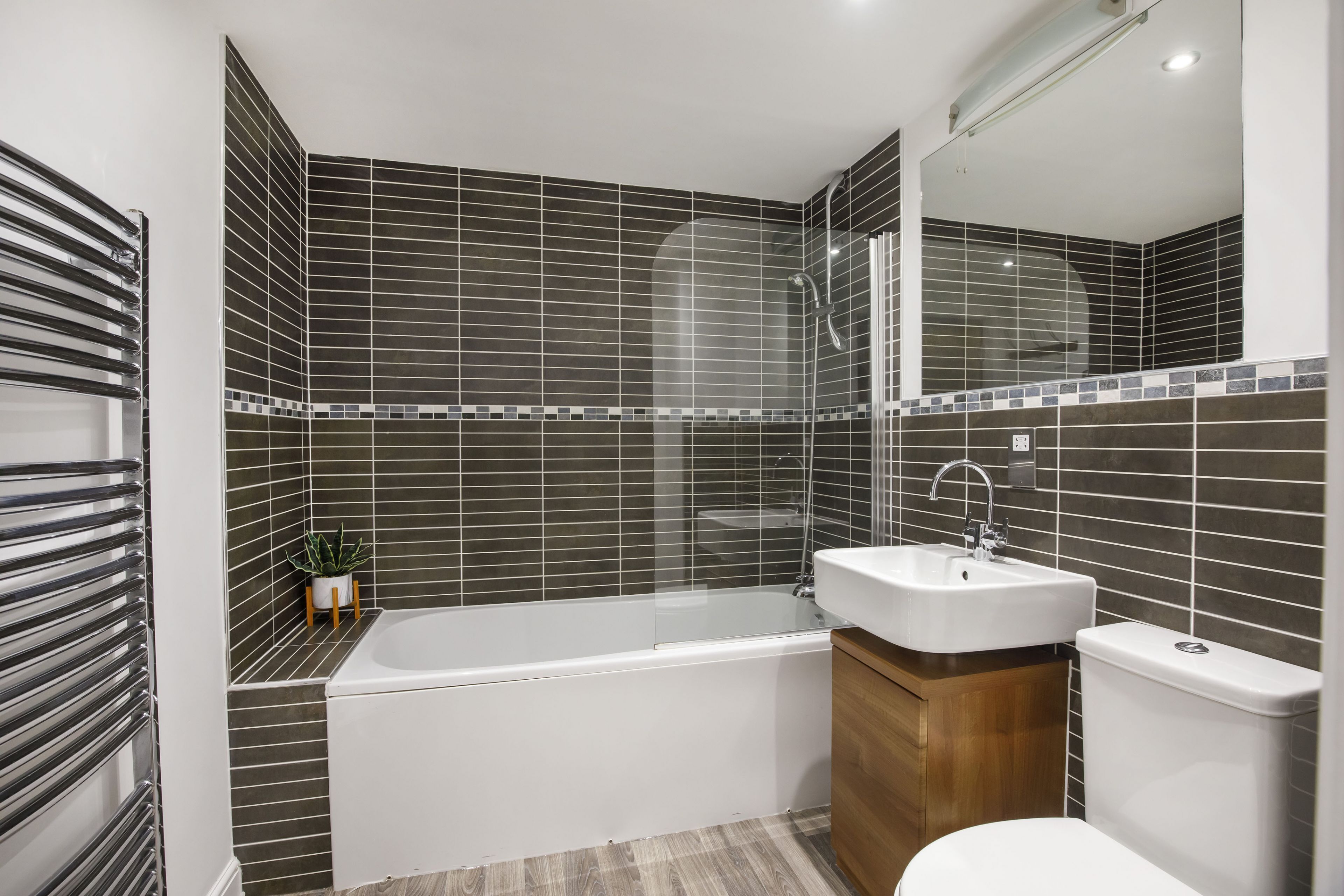 A modern bathroom with a bathtub, a sink, and a toilet.