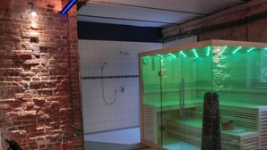 A spa room with a glass enclosure, a brick wall, and a shower area. - Apartment Alpha, haven of peace with complete facilities (Weenzen)
