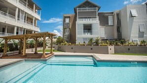 Ein modernes Hotel mit Pool, Sitzbereich im Freien und einem gepflegten Garten.