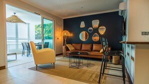 Ein modernes Wohnzimmer mit Sofa, Sessel, Couchtisch und dekorativen Spiegeln an der Wand.