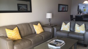 A living room with two sofas, a coffee table, and a lamp.