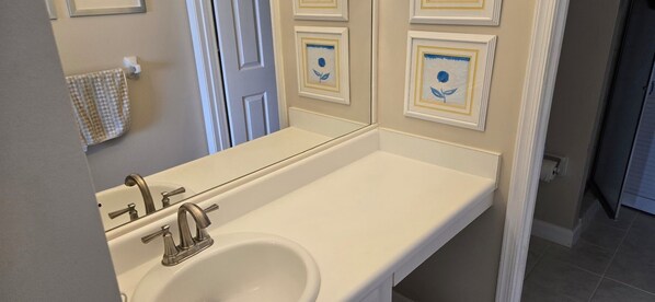 A bathroom with a white sink, a mirror, and a towel rack.