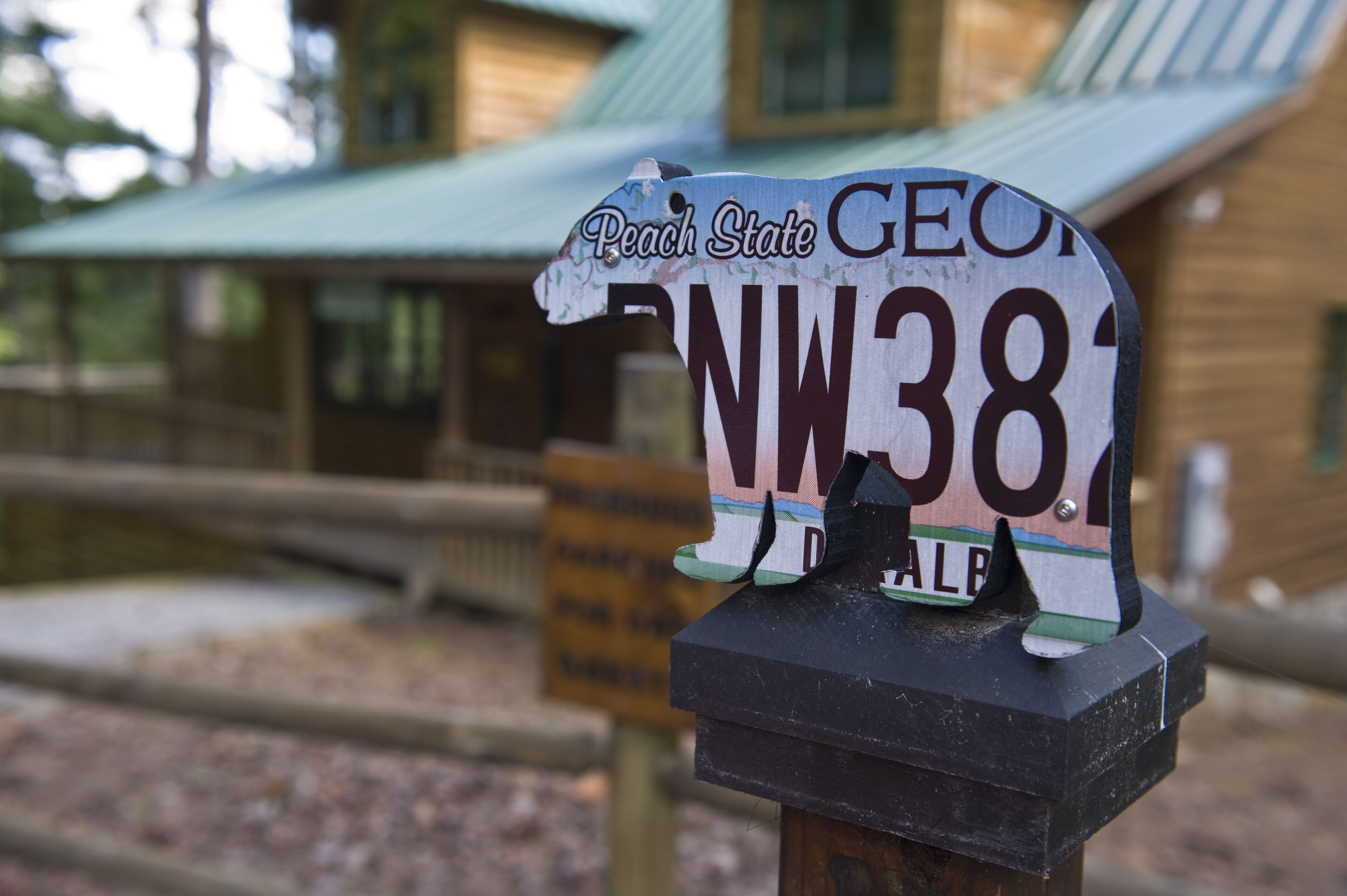 A wooden sign with a house in the background.