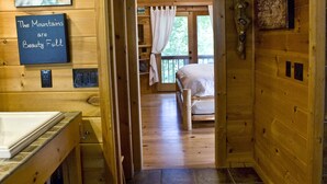 A wooden cabin interior with a hallway leading to a bedroom. - Mountain Cabin on Cooper Creek (Suches)