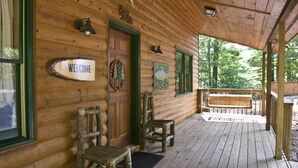 A wooden cabin with a porch, a welcome sign, and a Christmas wreath. - Mountain Cabin on Cooper Creek (Suches)