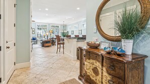 A spacious kitchen with a central island, a dining area with a chair, and a large mirror on the wall. - 27 Corine Ln, Close to Beach, Free Golf, Pool, Beach Shuttle* (Hilton Head Island)