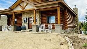 Une cabane en rondins avec des fondations en pierre, des poutres en bois et une cheminée.
